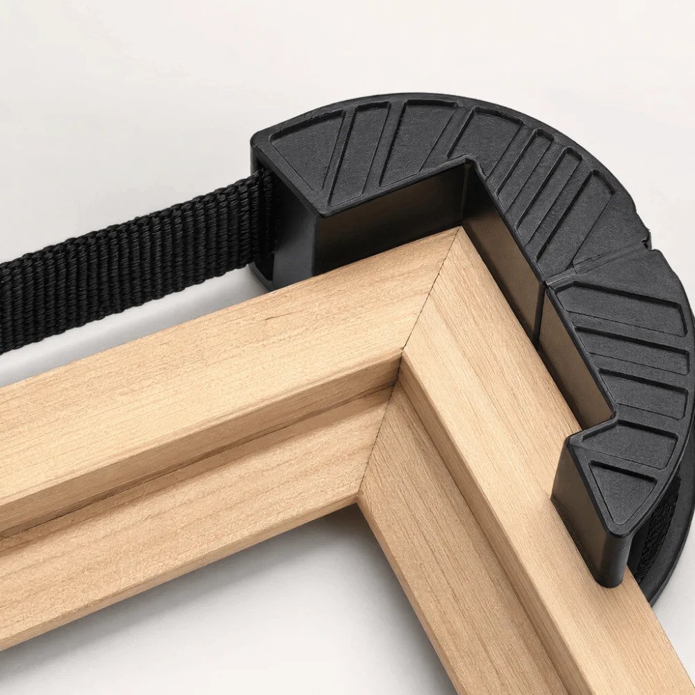 Presse à sangle utilisée sur un angle de cadre en bois